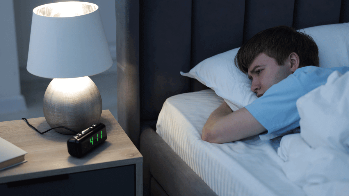 A man experiencing sleep problems in men and waking up tired.